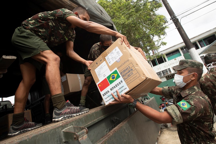 epa08496441 Brazilian Army soldiers unload 900 kilos of Personal Protective Equipment (PPE) material at the garrison hospital in the city of Tabatinga, Brazil, 19 June 2020. Military, police and healt ...