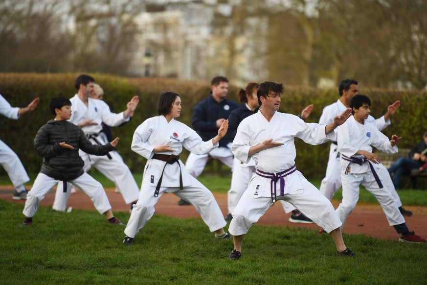 epaselect epa08312054 People practice martial arts in Primrose Hill in London, Britain, 21 March 2020. Britain&#039;s Prime Minister Boris Johnson has urged UK citizens to avoid unnecessary social con ...
