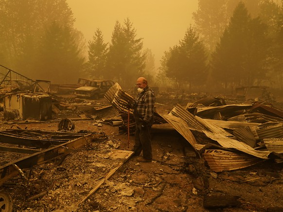 George Coble geht durch die �berreste seines Hauses im Bundesstaat Oregon, das durch einen Waldbrand zerst�rt wurde. Foto: John Locher/AP/dpa