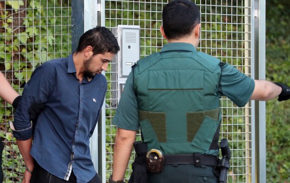 epa06155719 Salah El Karib, 34, one of four arrested in relation to the terrorist attacks in Catalonia, is taken to the Audiencia Nacional court in Madrid, Spain, 22 August 2017. The four suspects wil ...