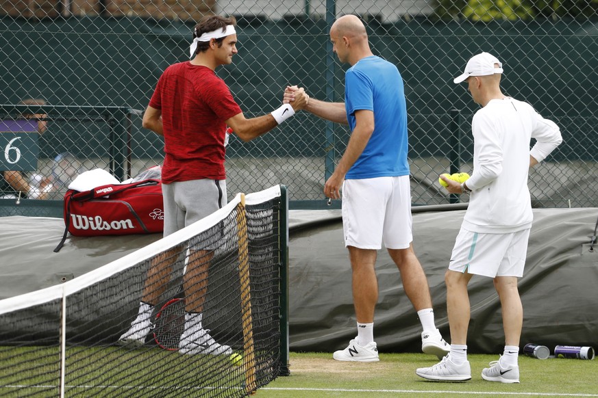 Roger Federer of Switzerland and his coach Ivan Ljubicic shake hands at the end of a training session, at the All England Lawn Tennis Championships in Wimbledon, London, Sunday, July 3, 2016. (KEYSTON ...
