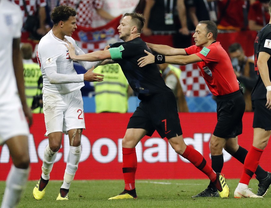 epa06882000 Dele Alli of England (L), Ivan Rakitic of Croatia (R) and referee Cuneyt Cakir of Turkey reacts during the FIFA World Cup 2018 semi final soccer match between Croatia and England in Moscow ...