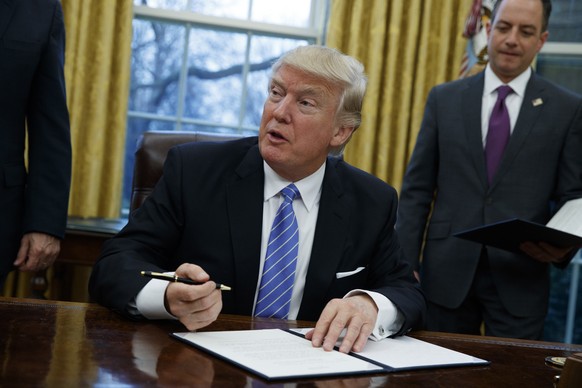 FILE - In this Monday, Jan. 23, 2017, file photo, President Donald Trump signs an executive order to withdraw the U.S. from the Trans-Pacific Partnership trade pact agreed to under the Obama administr ...
