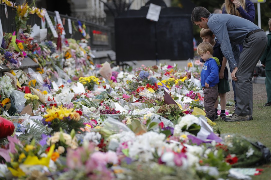 Mourners lay flowers on a wall at the Botanical Gardens in Christchurch, New Zealand, Monday, March 18, 2019. A steady stream of mourners paid tribute at makeshift memorial to the 50 people slain by a ...