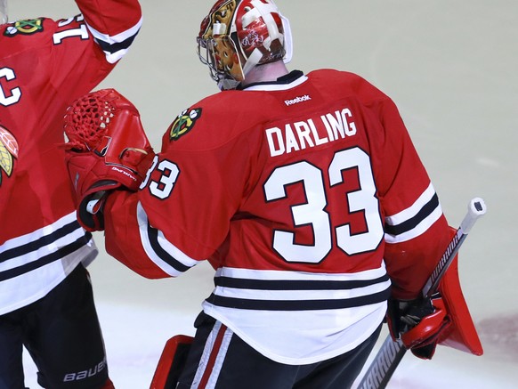 Chicago Blackhawks center Jonathan Toews, center, and left wing Tyler Motte (64) celebrate with goalie Scott Darling (33) after they won in an overtime shootout against the Toronto Maple Leafs. (AP Ph ...
