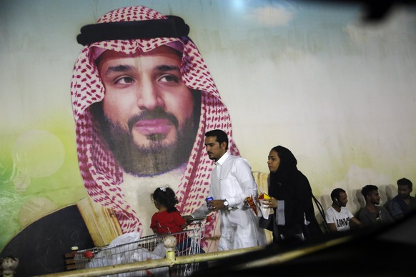 A Saudi family walk past a giant poster of Saudi Crown Prince Mohammed bin Salman, at a shopping mall in Jiddah, Saudi Arabia, Sunday, Sept. 15, 2019. The weekend drone attack on one of the world&#039 ...