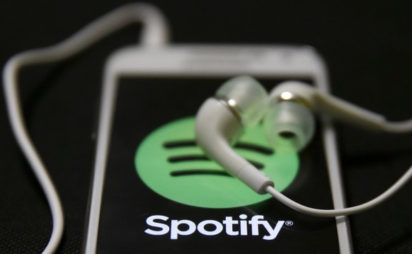 Earphones are seen on top of a smart phone with a Spotify logo on it, in Zenica February 20, 2014. Online music streaming service Spotify is recruiting a U.S. financial reporting specialist, adding to ...