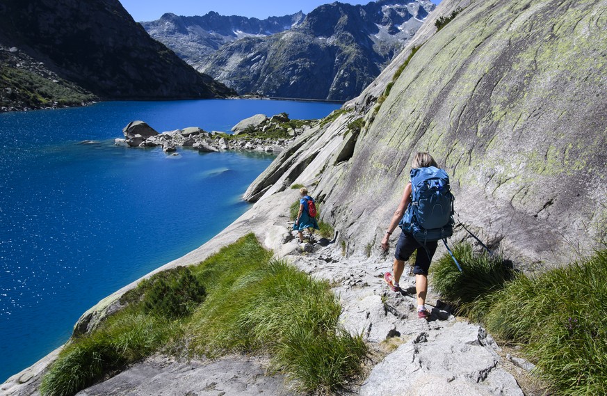 Nicole, right, and an another person walk above the Gelmer Lake during a beautiful sommer day, this Wednesday, September 4, 2019, in the Grimsel Region, canton Bern, Switzerland. The Gelmer Lake (Gelm ...
