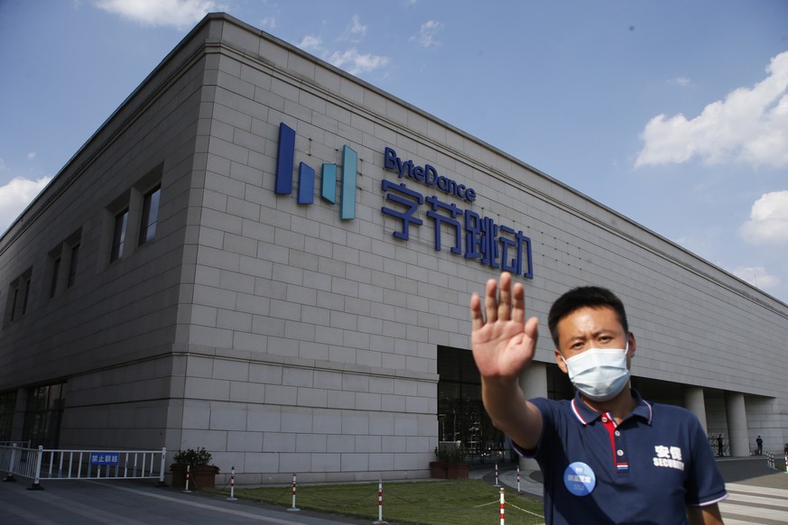 epaselect epa08581483 A security guard attempts to stop a photographer in front of the Bytedance headquarters building in Beijing, China, 03 August 2020. According to media reports, Microsoft is in ta ...