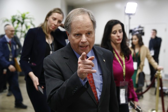 Sen. Doug Jones, D-Ala., center, walks on Capitol Hill in Washington during the impeachment trial of President Donald Trump on charges of abuse of power and obstruction of Congress, Wednesday, Feb. 5, ...