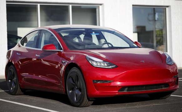 FILE- In this May 27, 2018, file photo, a 2018 Model 3 sedan sits at a Tesla dealership in Littleton, Colo. Tesla Inc. made 5,031 lower-priced Model 3 electric cars during the last week of June, surpa ...