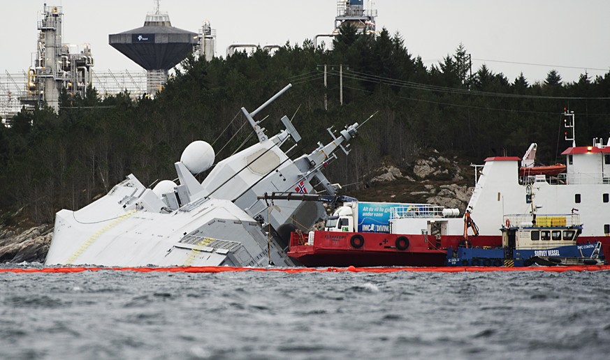 epa07155840 Rescue workers (R) secure the Norwegian frigate KNM Helge Ingstad after a collision with the tanker Sola TS, in a fjord near Oygarden, Norway, 10 November 2018. The frigate nearly capsized ...
