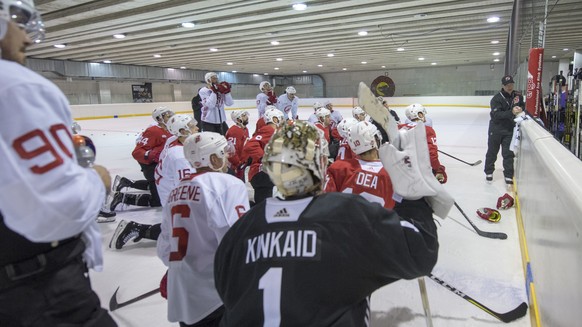 New Jersey Devils players listen to their head coach John Hynes, right, during the training at the Postfinance Arena in Bern, Switzerland, Sunday, September 30, 2018. The New Jersey Devils will face t ...