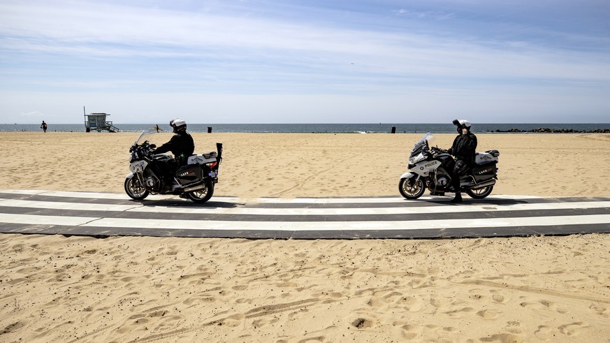 epa08329501 LAPD motorcycle officers patrol next to the beach amid the coronavirus pandemic in Venice, California, USA, 28 March 2020. Los Angeles Mayor Eric Garcetti ordered yesterday for all the bea ...
