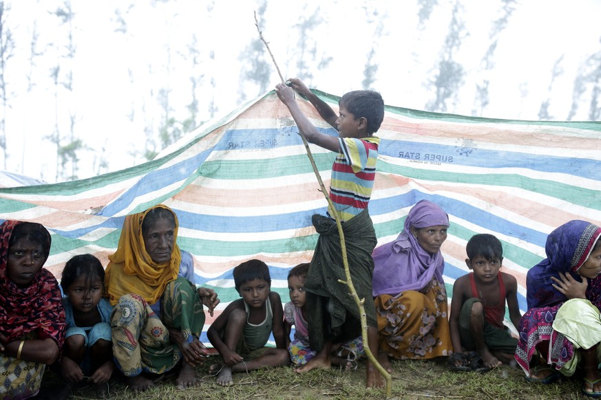 epaselect epa06210704 A Rohingya boy tries to hang a cloth to cover them from rain in the streets as they wait for releif at Shaplapur, Ukhiya, Bangladesh, 17 September 2017. According to UNHCR more t ...
