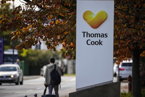 epa07868330 A man passes next to the logo of the travel company Thomas Cook in front of the headquarters of the German branch of Thomas Cook in Oberursel, Germany, 25 September 2019. British Thomas Co ...