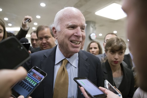 epa06271880 Republican Senator from Arizona John McCain (C) speaks to members of the news media at the Senate subway before a procedural vote to advance debate on tax reform, on Capitol Hill in Washin ...
