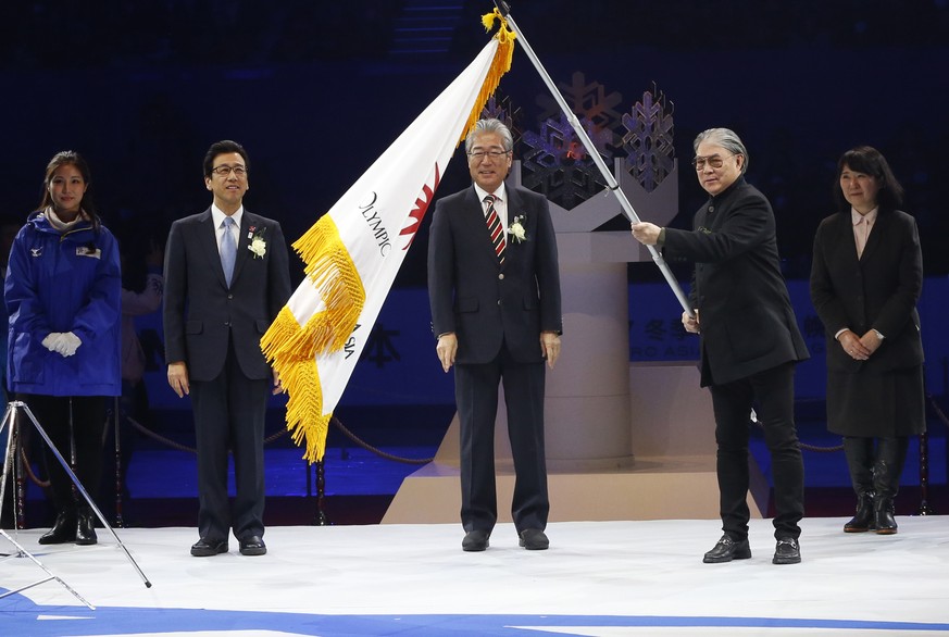 Timothy Fok, the Acting President of Olympic Council of Asia holds the OCA flag after he receives it from Japanese Olympic Committee President Tsunekazu Takeda,during the closing ceremony of the Asian ...