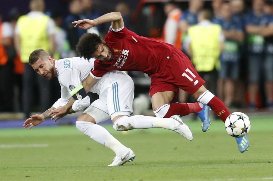 FILE - In this Saturday, May 26, 2018 file photo Real Madrid&#039;s Sergio Ramos, left, fouls Liverpool&#039;s Mohamed Salah during the Champions League Final soccer match between Real Madrid and Live ...