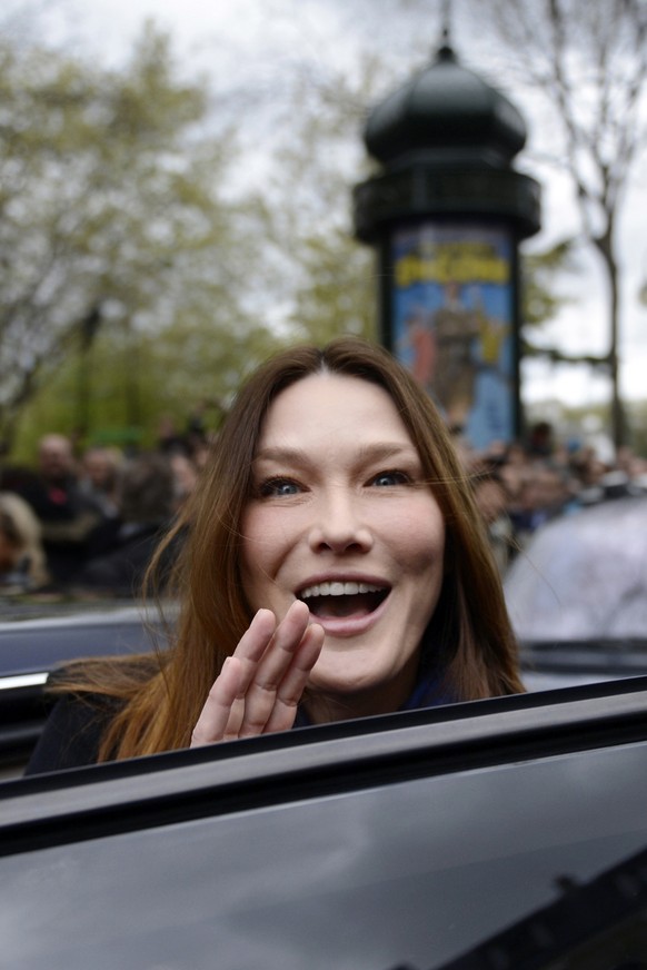 Carla Bruni-Sarkozy, the wife of French President and UMP party candidate Nicolas Sarkozy, gestures as she enters a car after they cast their ballots at a polling station in the first round of French  ...