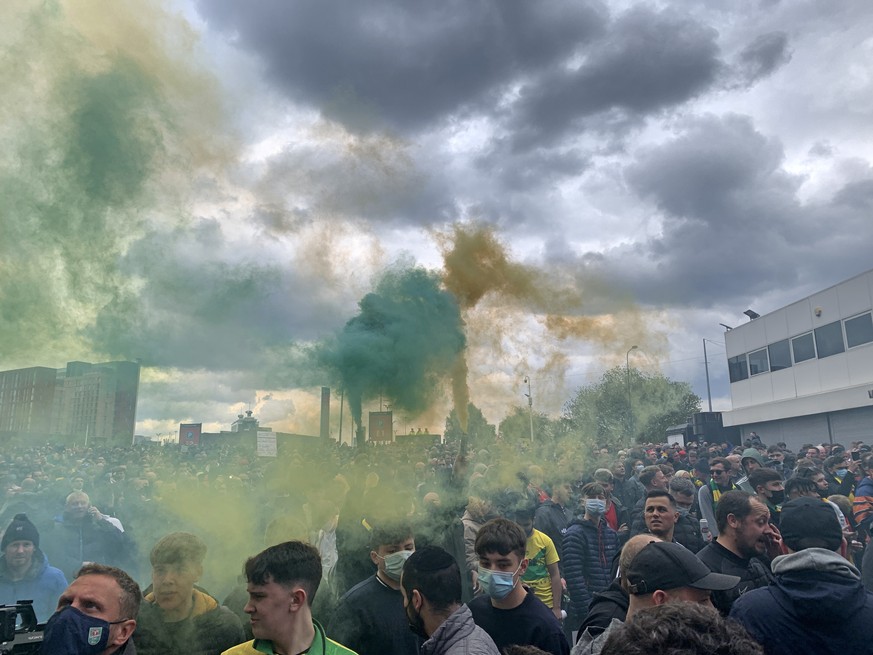 Manchester United fans hold flares as they protest outside of Old Trafford, during a protest against the Glazer family, owners of Manchester United, before their Premier League match against Liverpool ...