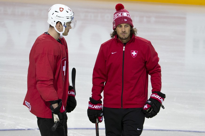 Patrick Fischer, head coach of Switzerland national ice hockey team, talks to his player forward Gregory Hofmann, left, during a Switzerland team training session at the IIHF 2021 World Championship,  ...
