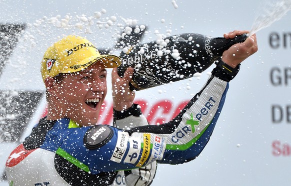 epa04313539 Swiss Moto2 driver Dominique Aegerter of the Technomag carXpert Team celebrates on the podium after winning the German Motorcycling Grand Prix at the Sachsenring circuit in Hohenstein-Erns ...