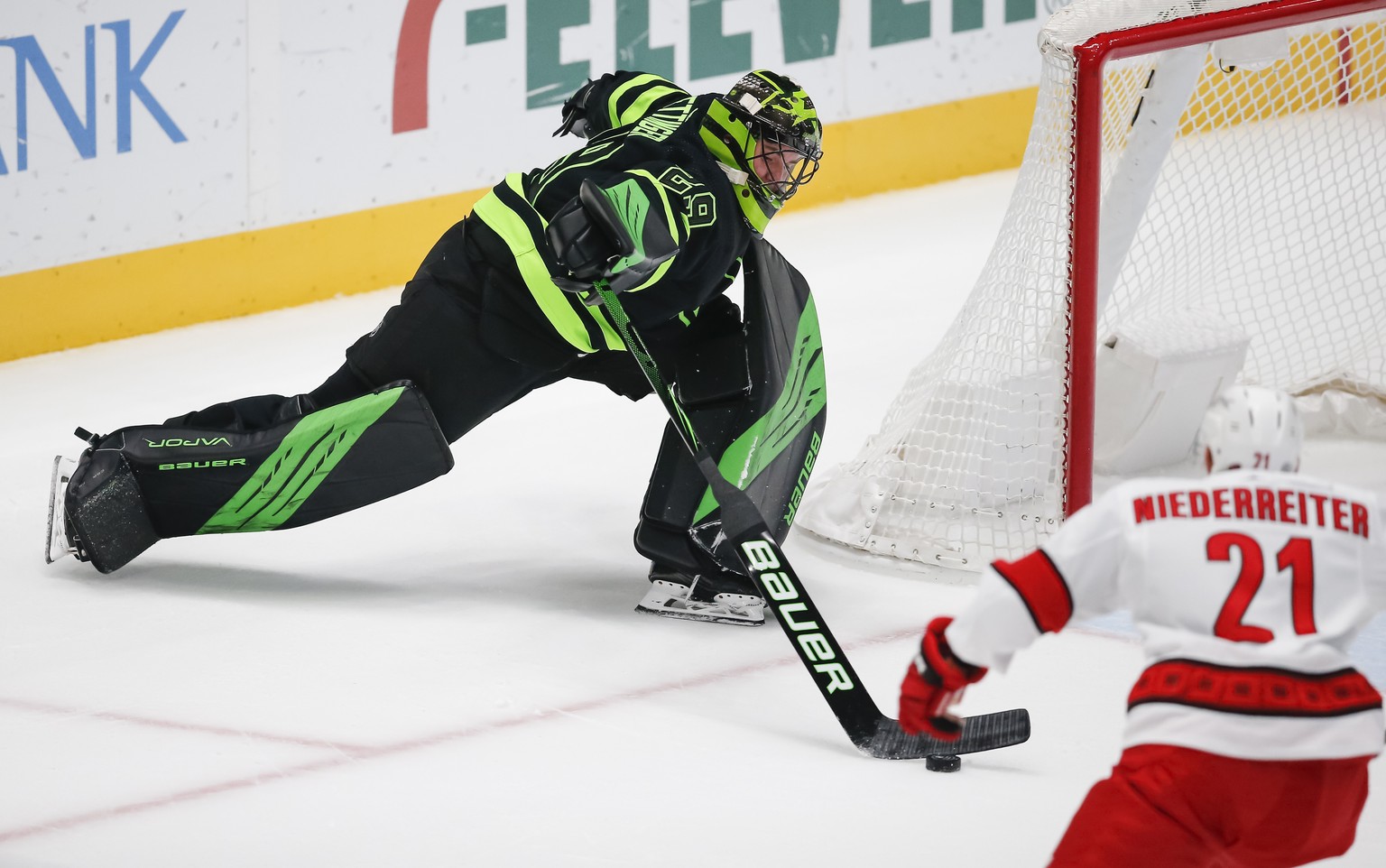 Dallas Stars goaltender Jake Oettinger (29) plays the puck away from Carolina Hurricanes forward Nino Niederreiter (21) during the first period of an NHL hockey game, Monday, April 26, 2021, in Dallas ...