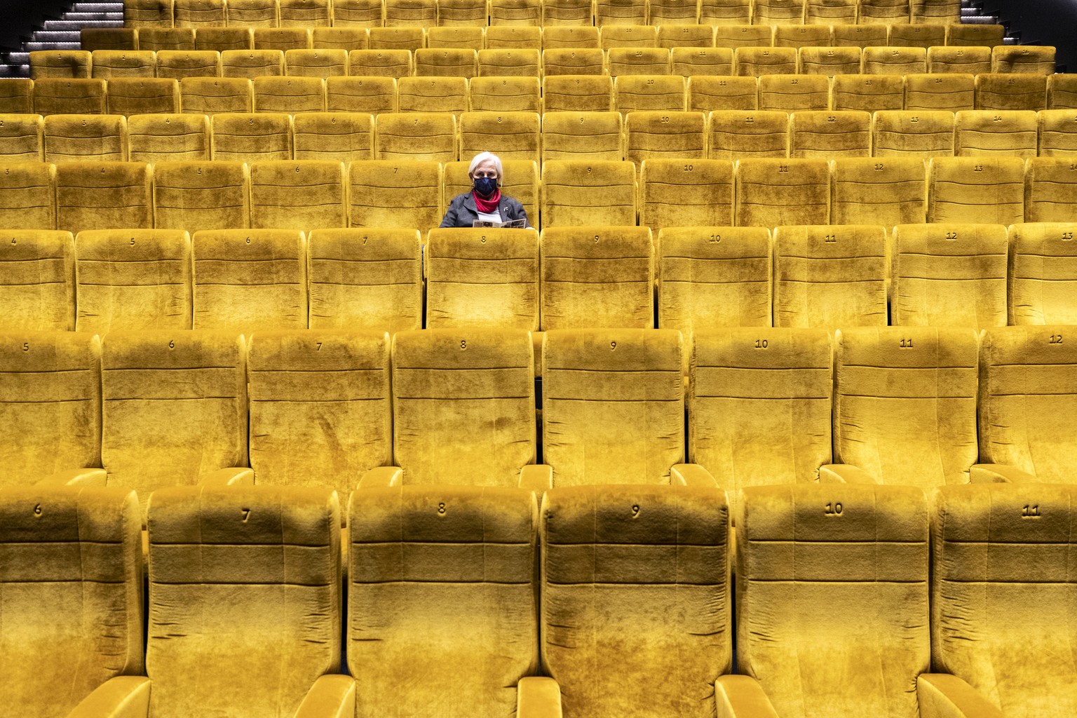 Eine Besucherin sitzt in einem Kinosaal im Kino Kosmos und wartet auf den Start eines Films, am Freitag, 6. November 2020, in Zuerich. Die Pandemie und die Schutzmassnahmen gegen das Coronavirus treff ...