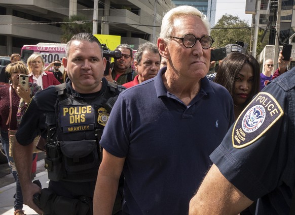 epa07319345 Roger Stone walks escorted by police officers after he speaks with the media outside the U.S. Federal Building and Courthouse in Fort Lauderdale, Florida, USA 25 January 2019. The American ...