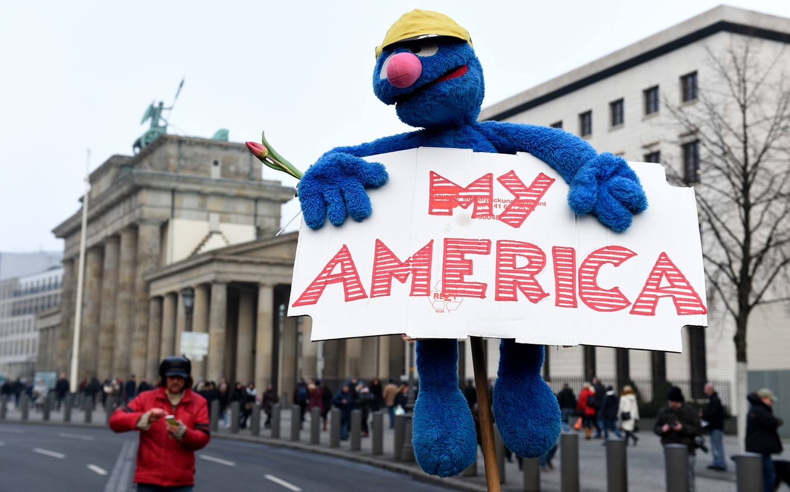 Ein Plakat mit der Aufschrift «my America» und eine Grobi-Puppe sind am 04.02.2017 vor der US-amerikanischen Botschaft in Berlin, bei einer Demonstration gegen Trumps Einreiseverbot, zusehen. (KEYSTON ...