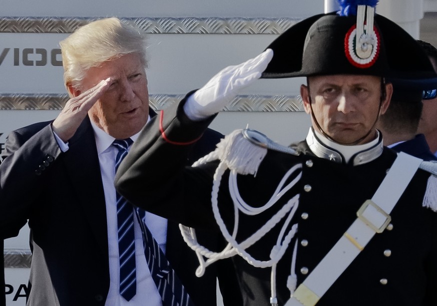US President Donald Trump salutes a Carabinieri paramilitary officer upon his arrival at Fiumicino&#039;s Leonardo Da Vinci International airport, near Rome, Tuesday, May 23, 2017. Trump is in Italy f ...