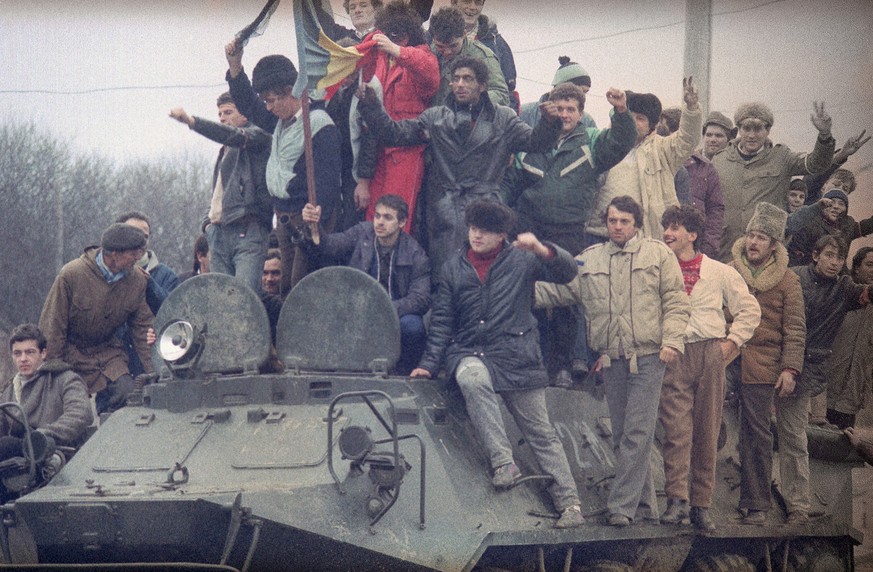 People at the armored carrier in the suburbs of Timisoara, Romania, while the fights between army and pro-Ceausescu forces on Saturday, Dec. 23, 1989. It is reported that over 5000 people were killed  ...
