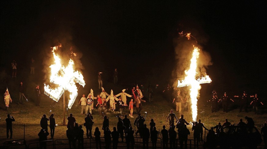 In this Saturday, April 23, 2016 photo, members of the Ku Klux Klan participate in cross and swastika burnings after a &quot;white pride&quot; rally in rural Paulding County near Cedar Town, Ga. The A ...