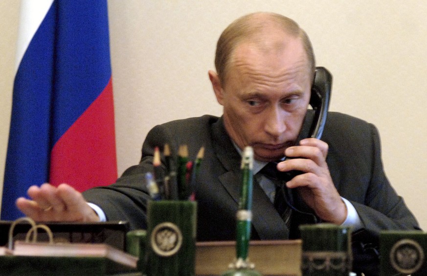 Russian President Vladimir Putin speaks by a phone at his residence Novo-Ogarevo, just outside Moscow on Friday, Aug. 5, 2005. A Russian mini-submarine with seven sailors aboard has been caught on a f ...
