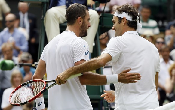 Roger Federer of Switzerland, right, shakes hands with Steve Johnson of the U.S after beating him in their men&#039;s singles match on day eight of the Wimbledon Tennis Championships in London, Monday ...