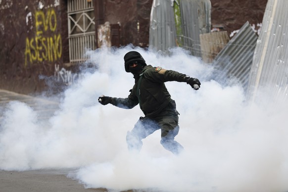 A Bolivian police officer hurls tear gas at backers of former President Evo Morales during clashes, in La Paz, Bolivia, Wednesday, Nov. 13, 2019. Bolivia&#039;s new interim president Jeanine Anez face ...