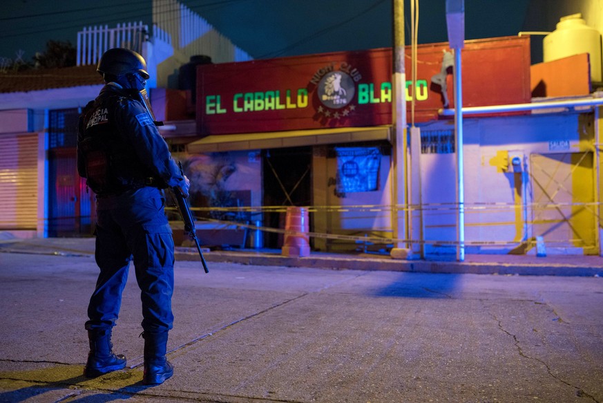 epa07799348 A police officer guards in the early hours in front of the El Caballo Blanco bar, attacked the previous night by an armed group, in Coatzacoalcos, in the state of Veracruz, Mexico, 28 Augu ...