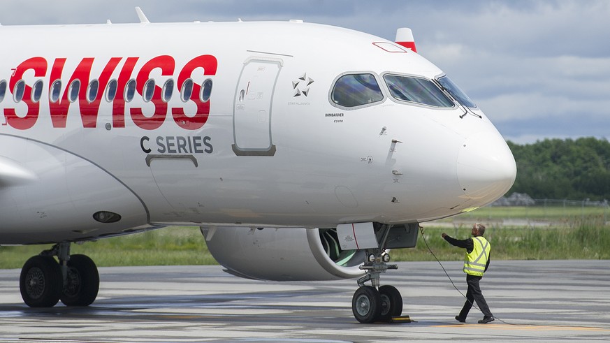 A ground crew operator detaches a cable from a Bombardier C Series 100 aircraft prior to a demonstration flight in Mirabel, Quebec, Wednesday, June 29, 2016. (Graham Hughes/The Canadian Press via AP)