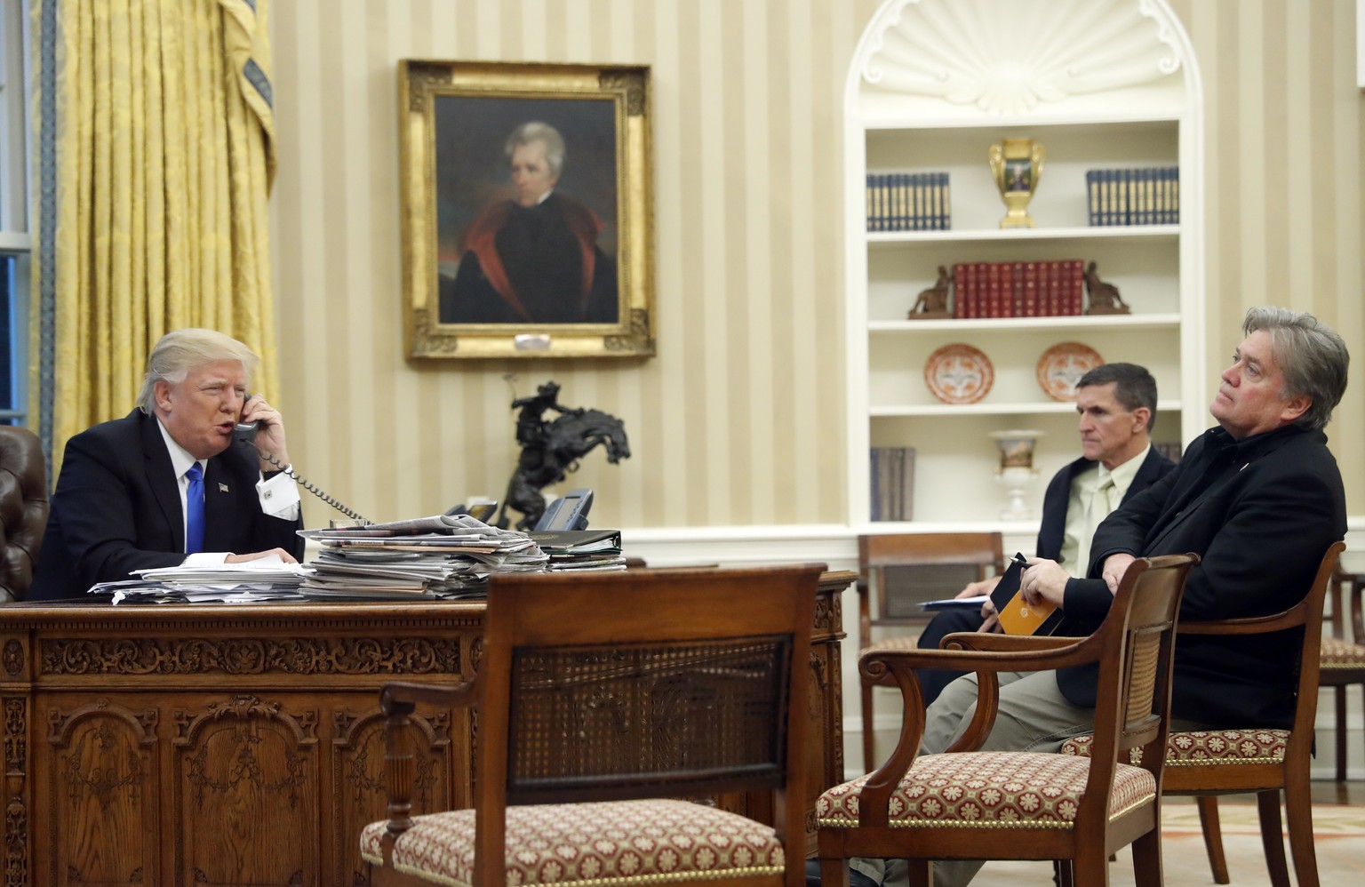 President Donald Trump speaks on the phone with Prime Minister of Australia Malcolm Turnbull, with National Security Adviser Michael Flynn, center, and chief strategist Steve Bannon, right, in the Ova ...