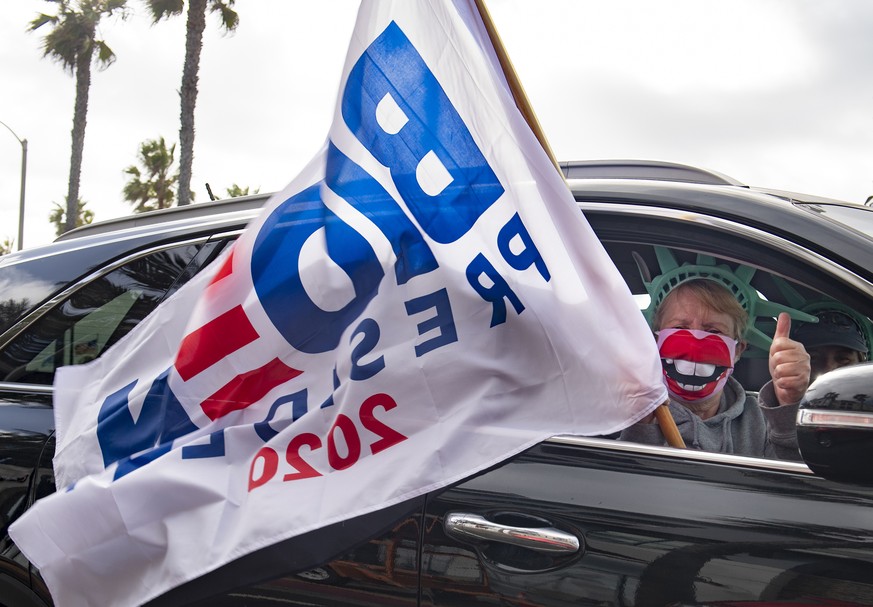 A Biden supporter wears a big smile as she cruises down Pacific Coast Highway as demonstrators on both sides rallying after election results were released on Saturday, Nov. 7, 2020, near the Huntingto ...