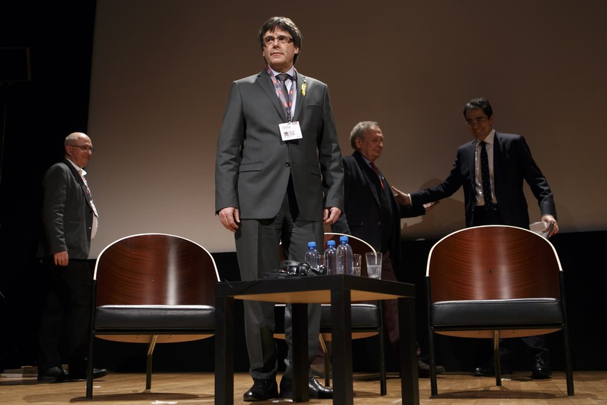 Catalan leader Carles Puigdemont, 2nd left, attends a panel titled &quot;Self-determination&quot;, past Nicolas Levrat,Êleft, Director of Department International Public Law and International Organisa ...