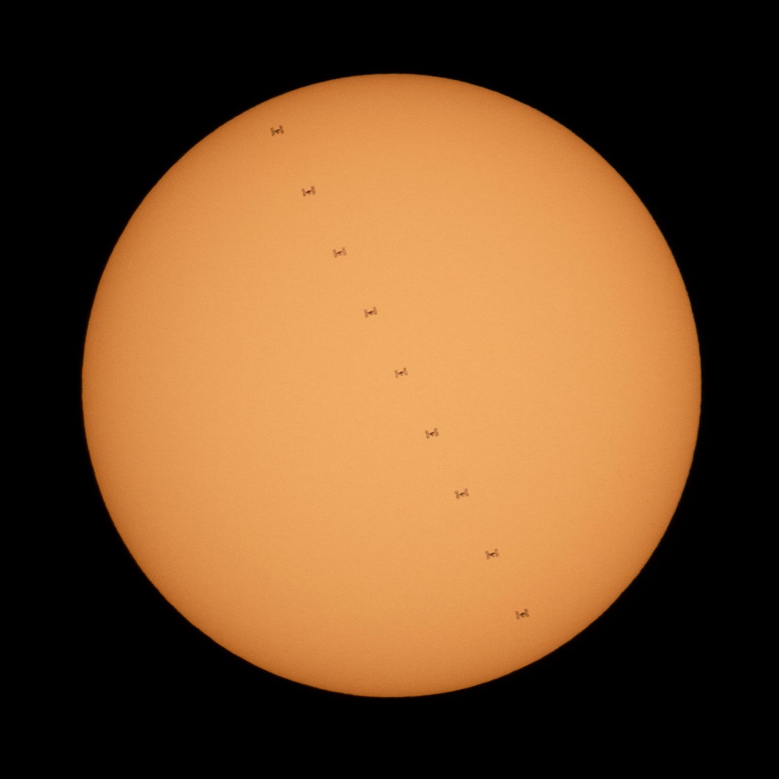 This composite image, made from nine frames, shows the International Space Station, with a crew of three onboard, in silhouette as it transits the Sun at roughly five miles per second, Sunday, Oct. 7, ...