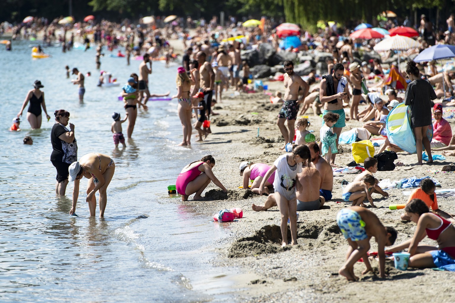 epa08458262 People enjoy the warm spring weather on the &#039;vidy&#039; beach of the Lake Geneva during the state of emergency due to the ongoing coronavirus COVID-19 pandemic in Lausanne, Switzerlan ...