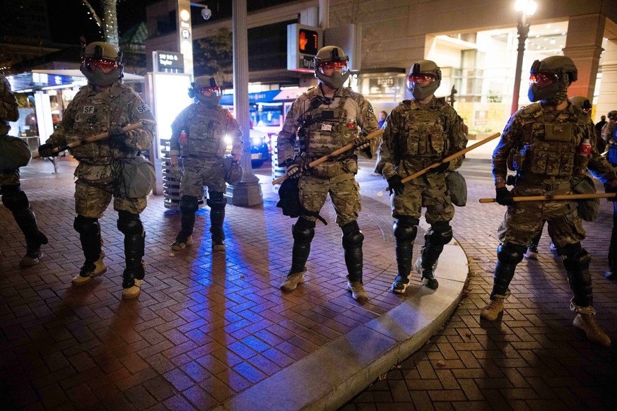 epa08799788 Soldiers with the National Guard help local police disperse antifascist protesters following the US presidential elections in Portland, Oregon, USA, 04 November 2020. Portland Police decla ...