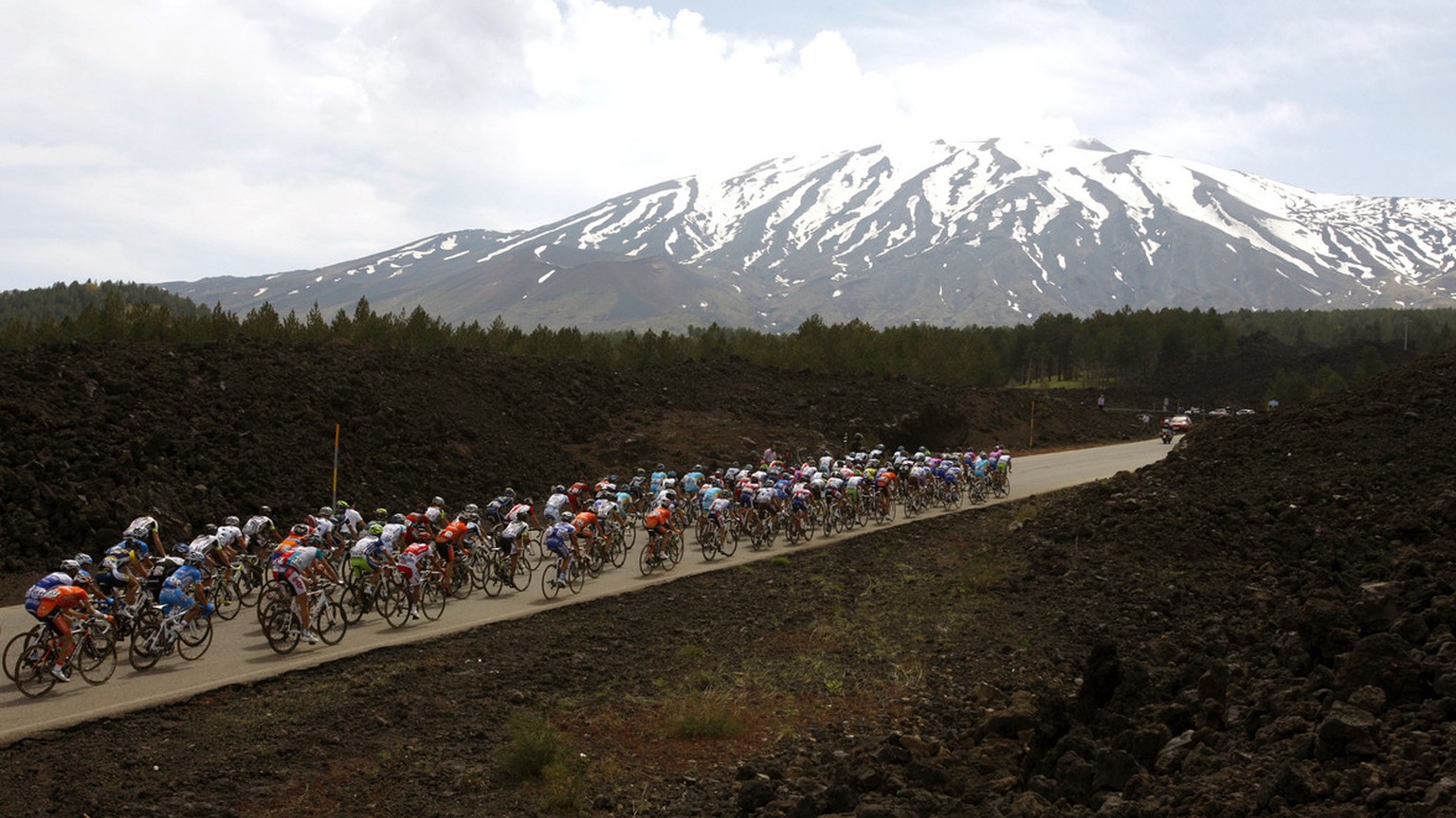 Cyclists pedal as the Etna volcano is seen in background during the 9th stage of the Giro d&#039;Italia, Tour of Italy cycling race, from Messina to Etna, Sunday, May 15, 2011. Giro d&#039;Italia favo ...