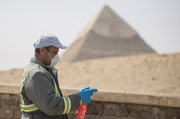 epaselect epa08320460 A member of medical team sprays disinfectants at Giza pyramids in Egypt, Egypt, 25 March 2020. Egyptian authorities announce a two-week curfew, starting from 25 March, during whi ...