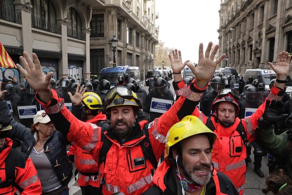 Firefighters help to control the demonstrators during a protest against Spain&#039;s cabinet holding a meeting in Barcelona Spain, Friday Dec. 21, 2018. Scuffles broke out between protesters trying to ...