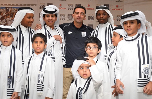 epa04793793 Former FC Barcelona&#039;s player Xavi Hernandez poses with young fans during his presentation as new Al-Sadd club player at a press conference in Doha, Qatar, 11 June 2015. The 35-year-ol ...