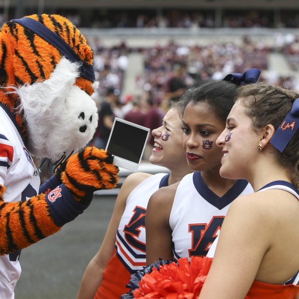November 4, 2017 - College Station, TX, USA - Auburn Tigers mascot Aubie shows a Polaroid photo to a group of Auburn cheerleaders during the first quarter of an NCAA College League USA college footbal ...